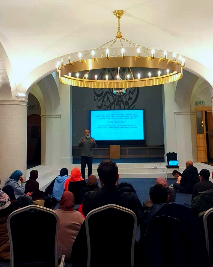 Mubeen Azam seated, speaking during a Time for Change session in Birmingham